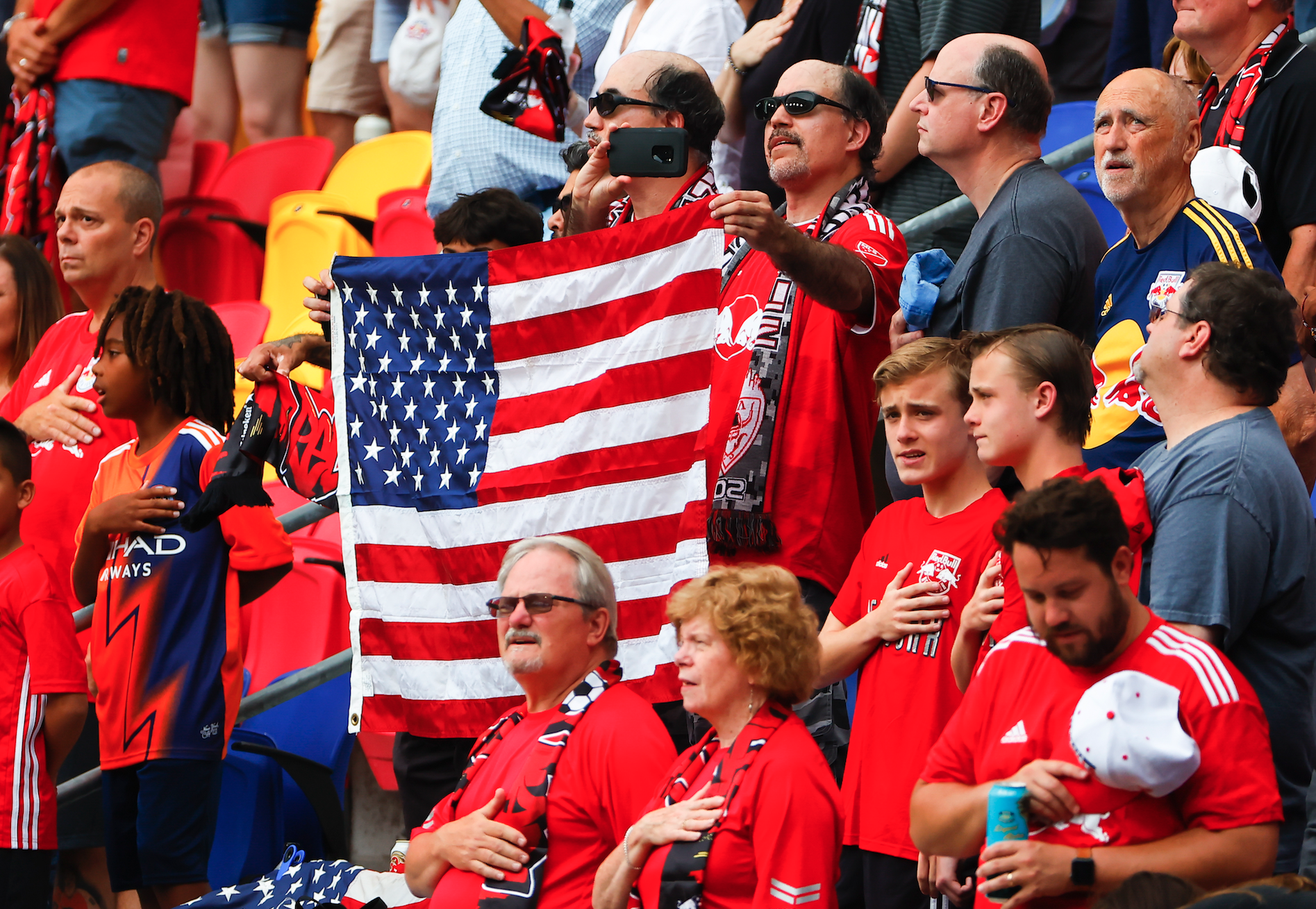 Man holds American flag in stadium seating