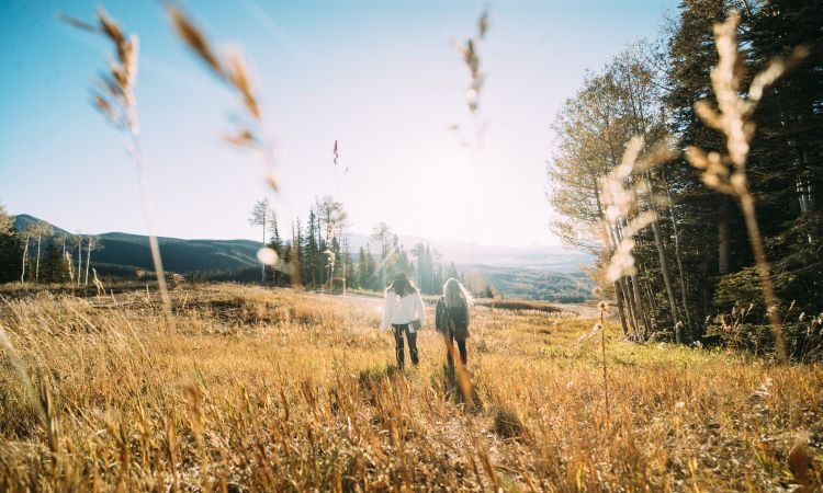 Two women walking through a field.
